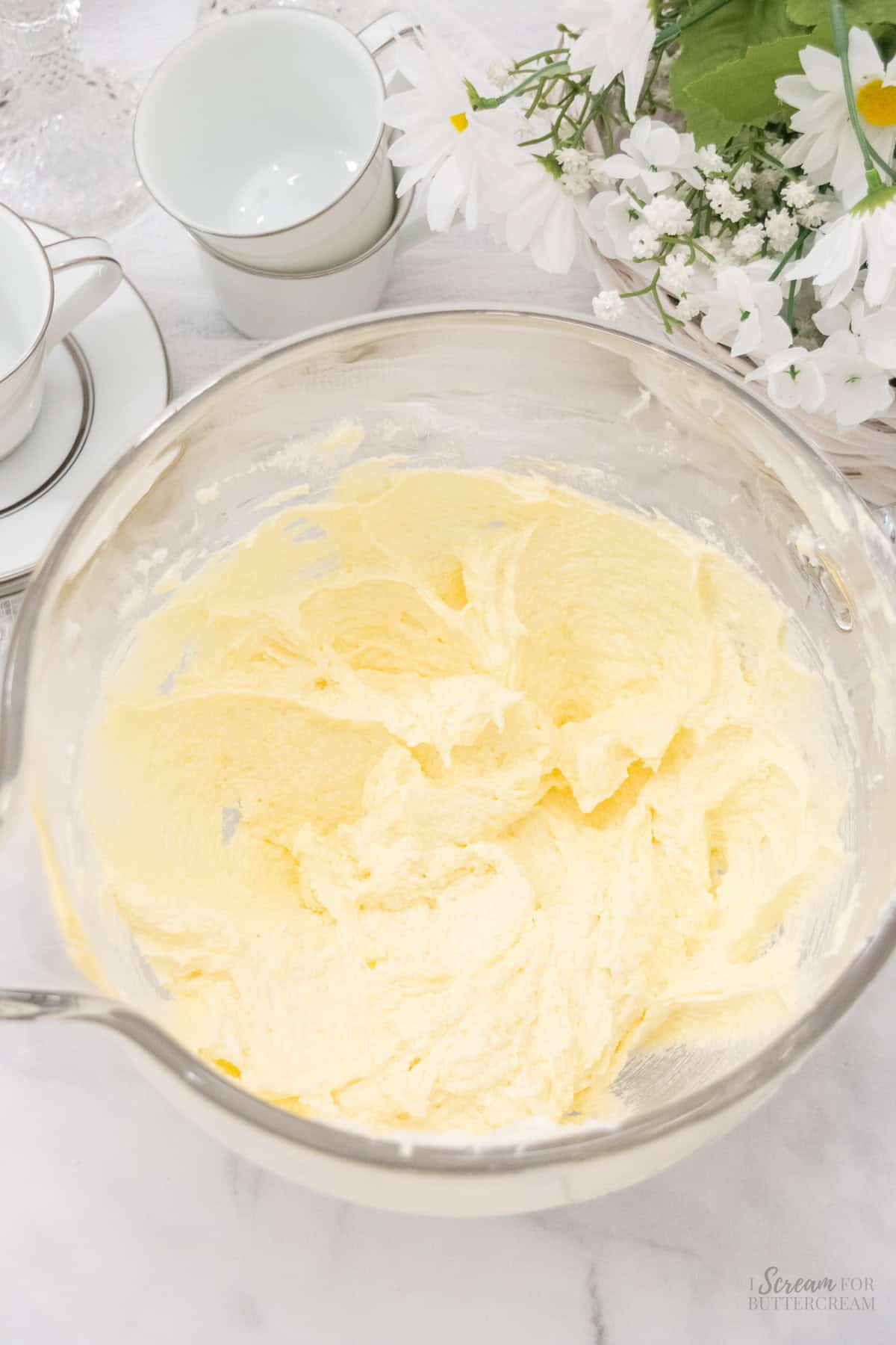 Whipped sugar and butter in a glass mixing bowl.