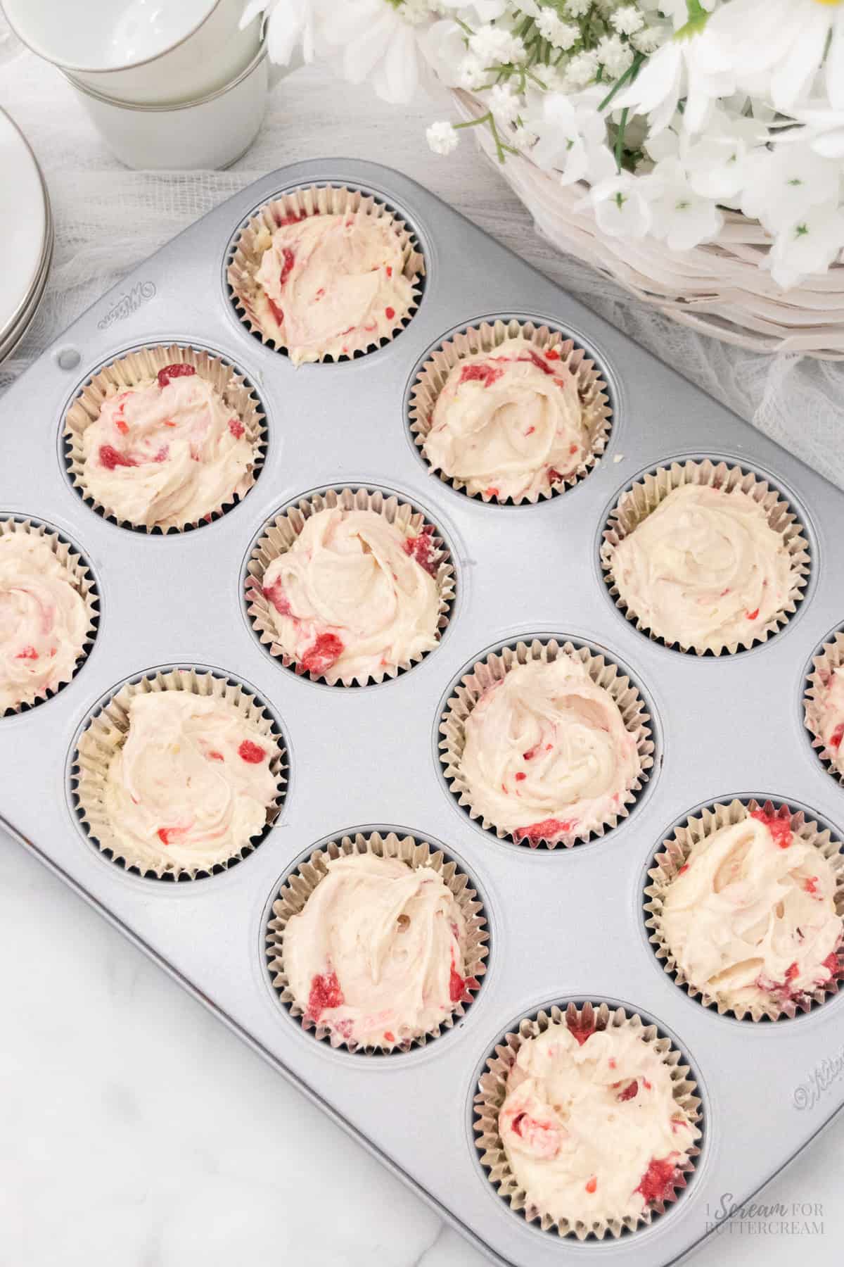 Raspberry cupcake batter in cupcake liners.