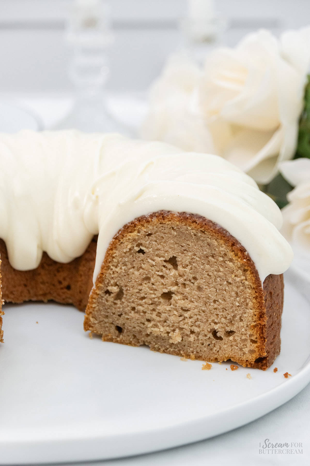 Spice cake with glaze that is cut and on a white platter.