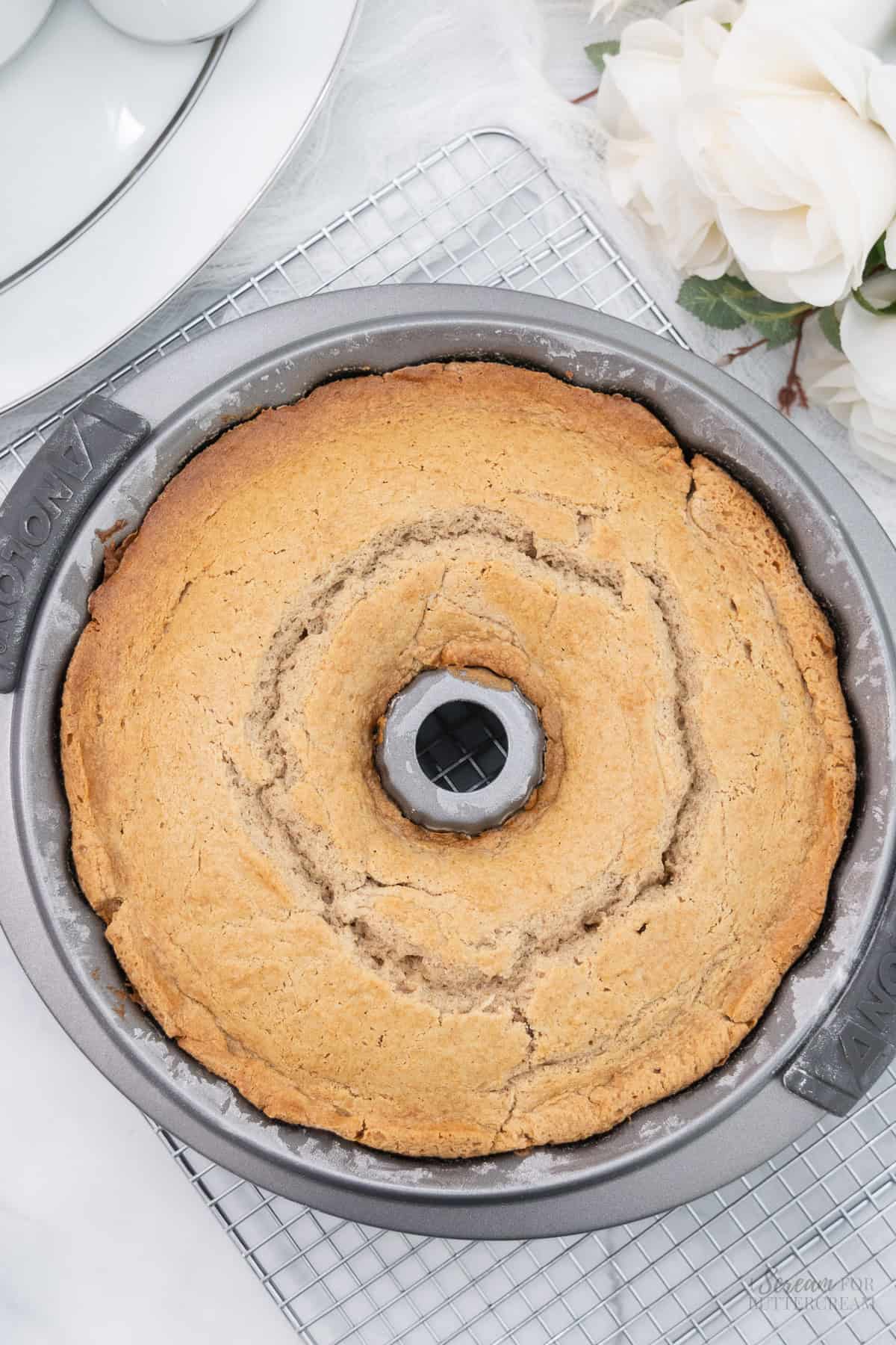 Baked cream cheese spice cake in a bundt pan on a cooling rack.