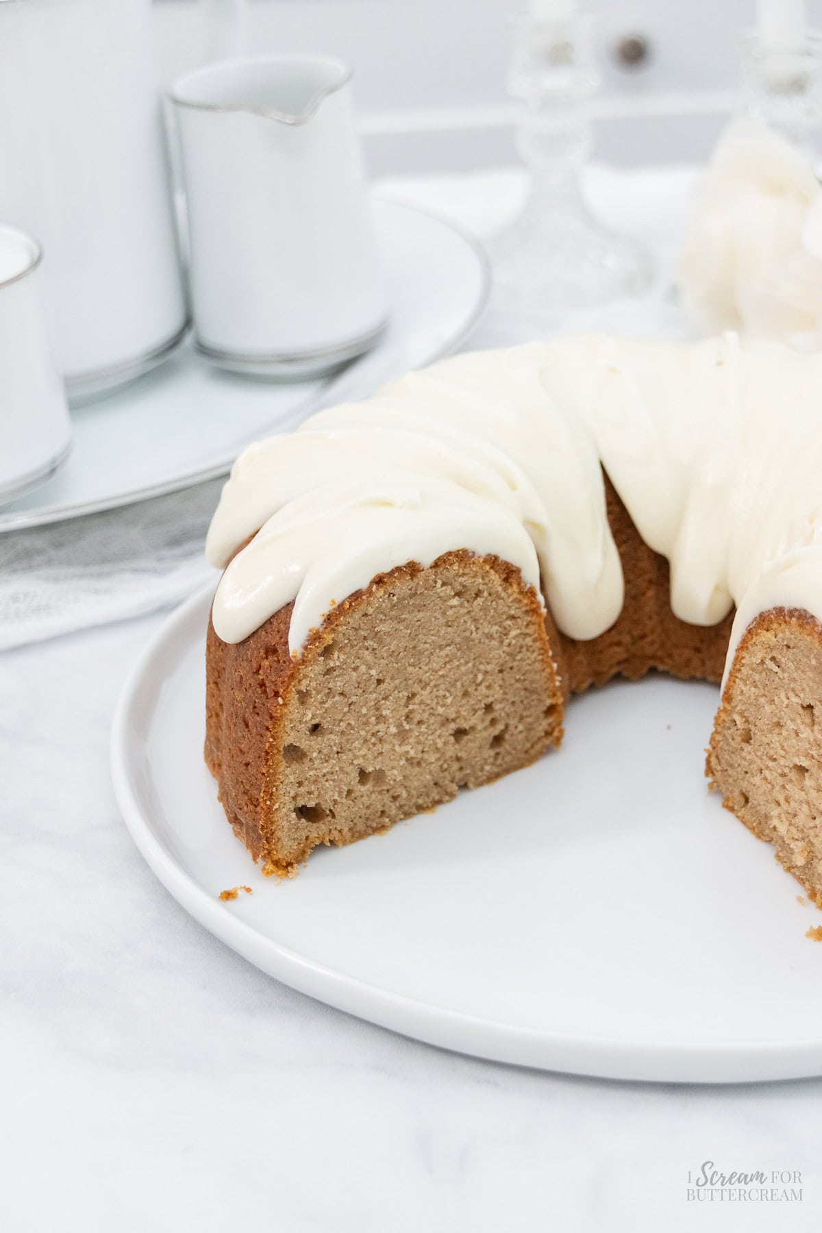 Spice bundt cake with glaze on a white platter.