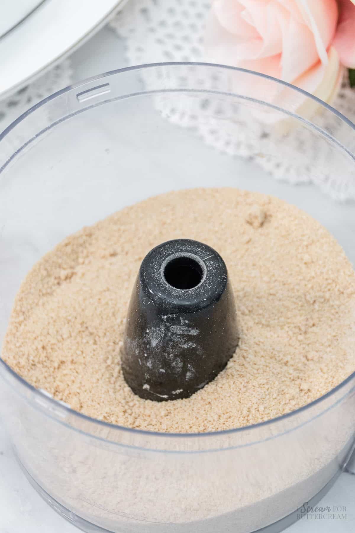 A food processor bowl filled with finely ground cinnamon-sugar mixture, ready for use in baking.