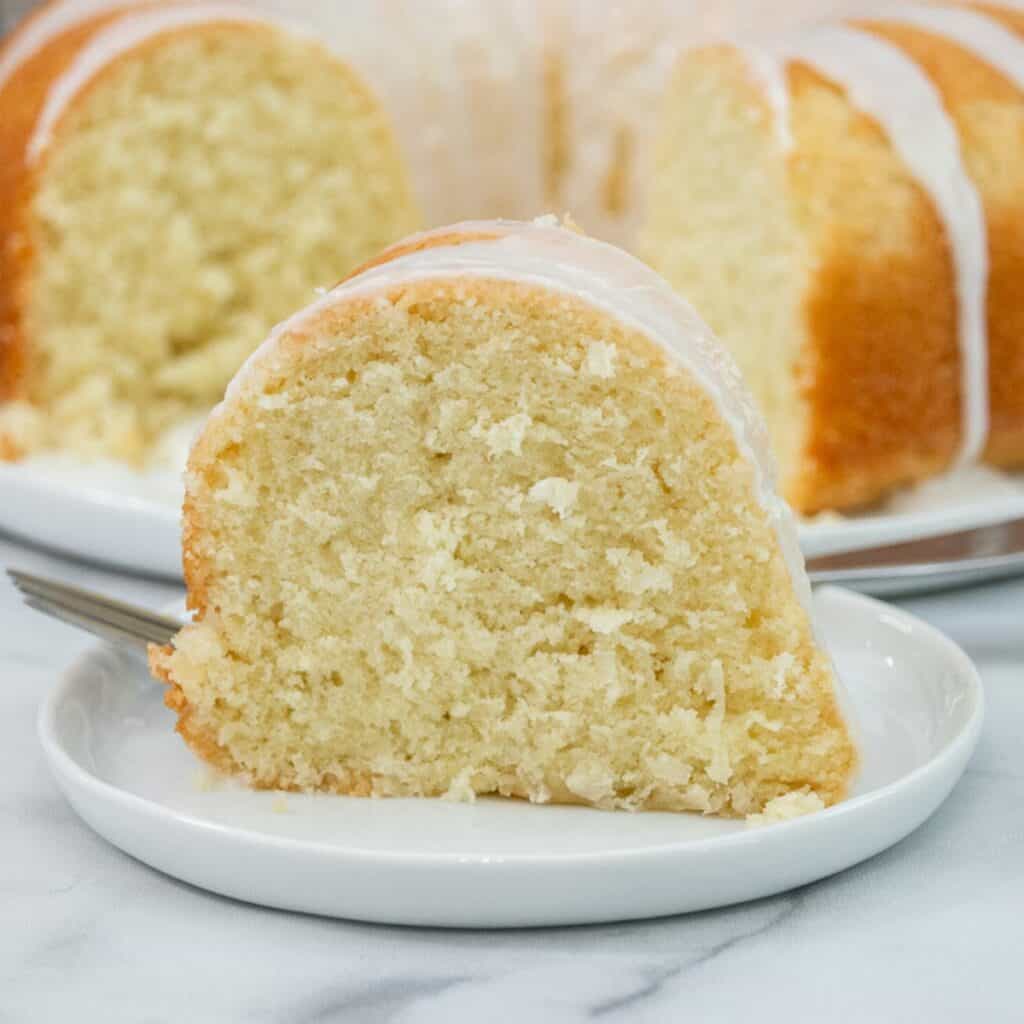 Close-up slice of moist coconut pound cake on a white plate.