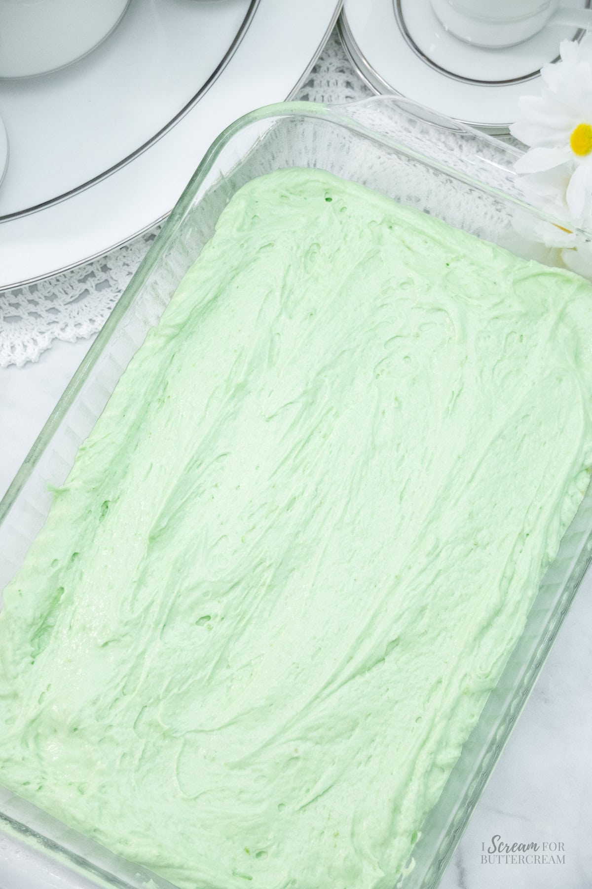 Key lime cake batter spread evenly in a glass baking dish, ready to bake.