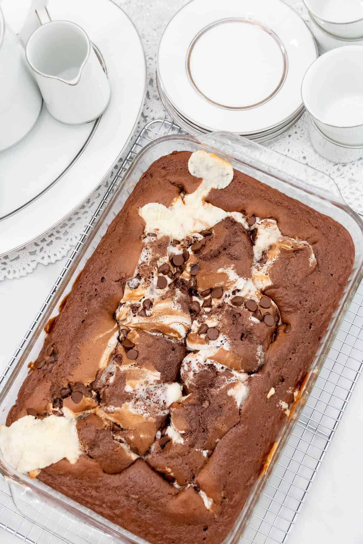 Overhead view of chocolate earthquake cake in a glass 13x9 baking dish with swirls of cream cheese and chocolate chips.